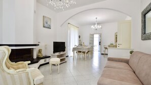 A living room with a TV, sofa, and dining area. - Cozy apartment in Capezzano Pianore (Capezzano Pianore)