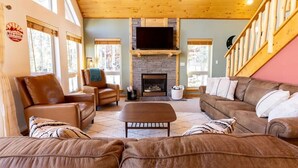 A cozy living room with leather sofas, a fireplace, and a television. - Snow Banks Lodge, Beautiful Home in Angel Fire (Angel Fire)