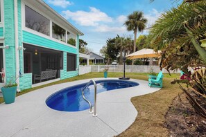 A swimming pool with a metal ladder, surrounded by a concrete deck. - After Dune Delight by Tybee Vacation Rentals (Tybee Island)