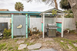 A backyard with a grill and a shed. - After Dune Delight by Tybee Vacation Rentals (Tybee Island)