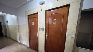 A hallway with two wooden doors, each with a number plate and a keyhole. - Charming 2-room Temporary Stay in the Heart of San Telmo (Buenos Aires)