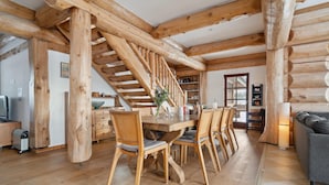 Un interno in legno con zona pranzo, una scala e un soggiorno.