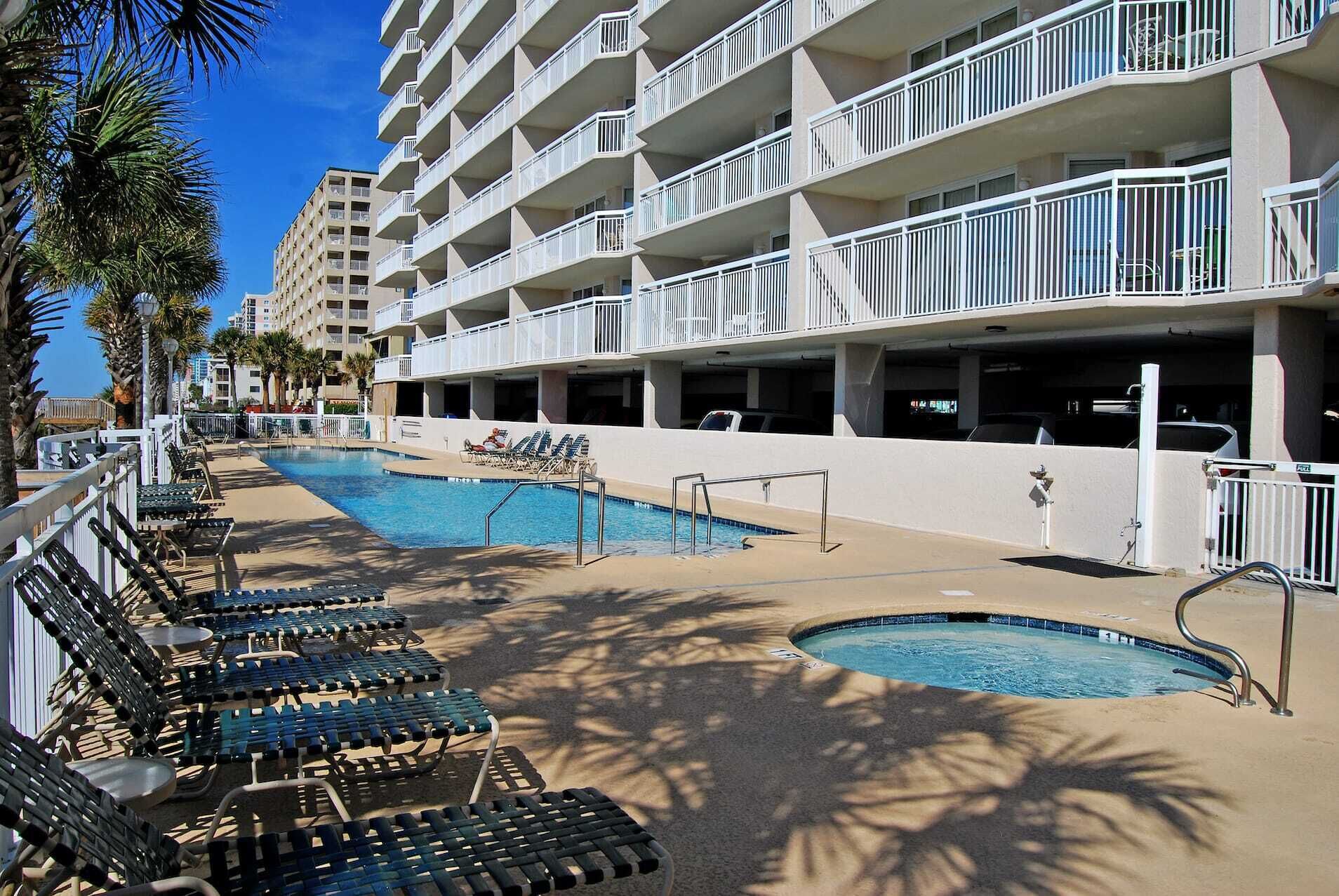 Um hotel com área de piscina, várias varandas e garagem.