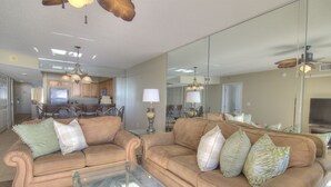 A living room with two brown sofas, a glass coffee table, and a kitchen in the background. - Views for days! Oceanfront 3 Bedroom 3 Bath Crescent Shores North Myrtle Beach (North Myrtle Beach)