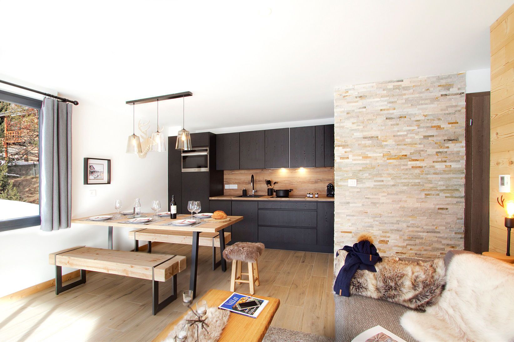 A modern living space with a kitchen, dining area, and a cozy seating area.