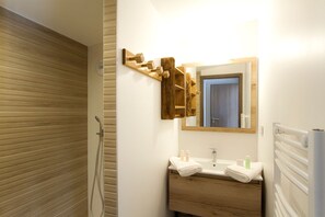 Enjoy a refreshing shower in the bathroom with a shower enclosure, vanity, and sink.