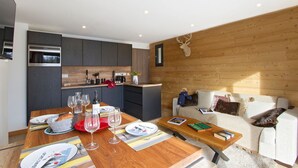 A modern kitchen with dark cabinets, a wooden countertop, and a built-in oven. - Près du Télémixte du Diable | T2 + terrasse & Wifi (Les Deux Alpes)