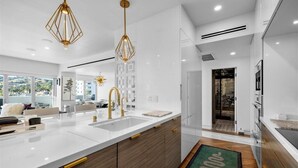 Una cucina moderna con un'isola grande, luci a sospensione e vista sull'esterno.