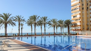 A pool area with clear blue water, surrounded by palm trees and a view of the sea. - Nice apartment in Algarrobo-Costa (Algarrobo-Costa)