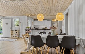Enjoy meals in this stylish dining area with a large window, comfortable seating for four, and a beautiful vase with fresh flowers.