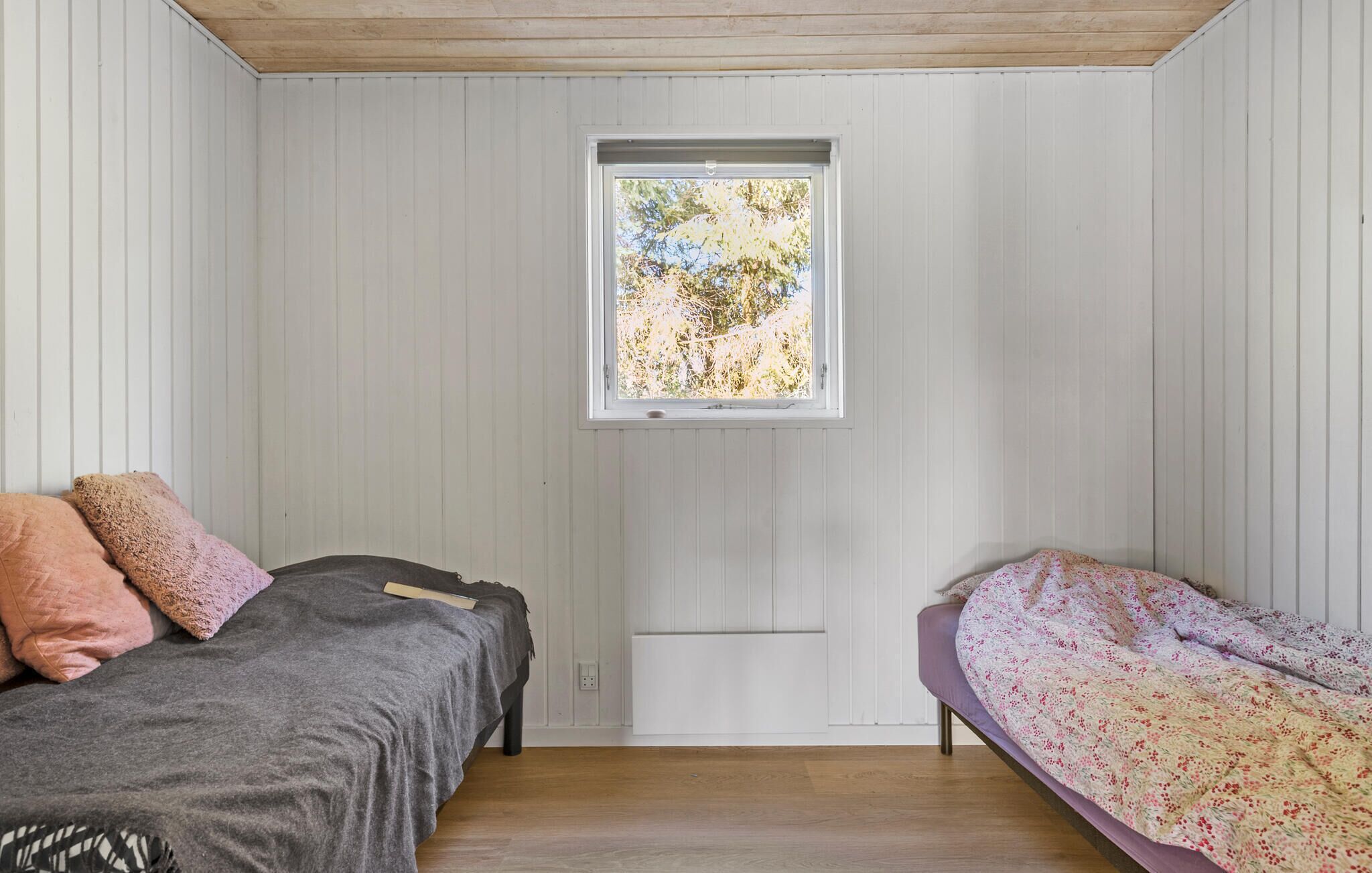Une chambre avec deux lits, un de chaque côté d’une porte centrale.
