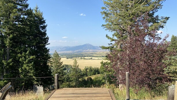 A wooden deck with a bench overlooking a scenic landscape. - Unique 2Bds/1Bath Yurt | Kitchen, Wifi, Views! (Bozeman)