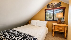 Una camera da letto con un letto, un comodino, una lampada e una finestra con persiane.