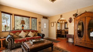A living room with a leather sofa, a wooden coffee table, and a large mirror.