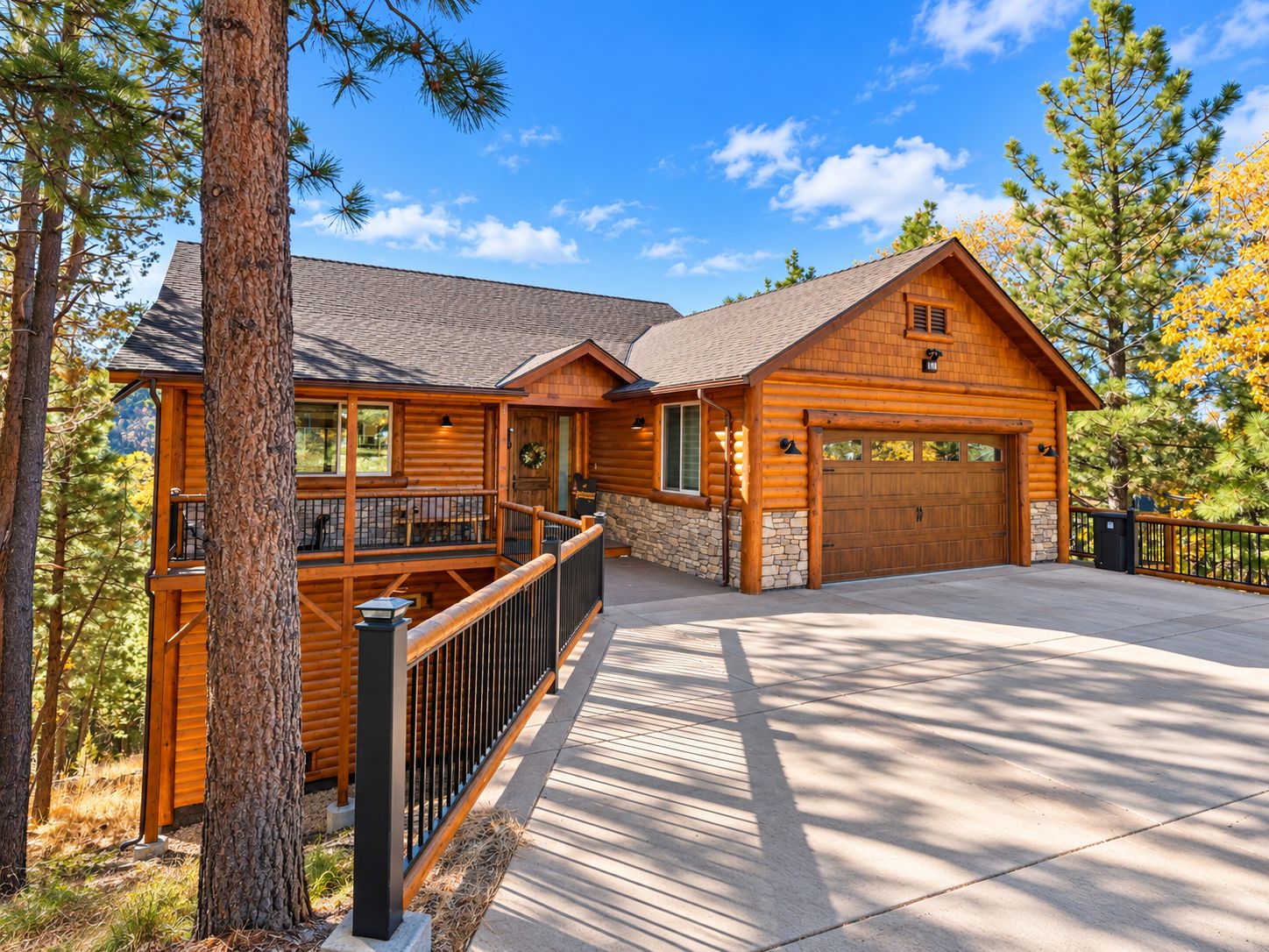 A log cabin with a stone foundation, a balcony, and a garage.