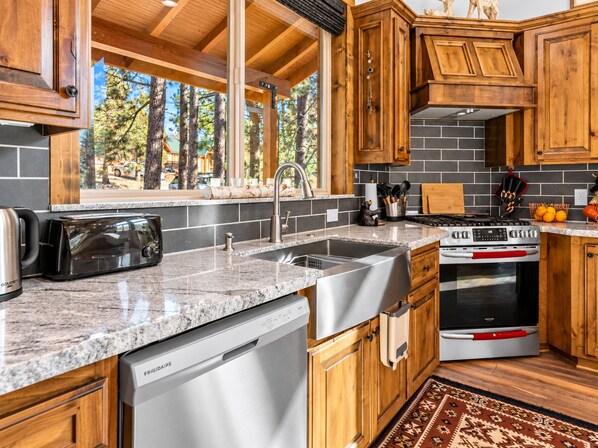 A modern kitchen with granite countertops, stainless steel appliances, and wooden cabinetry.
