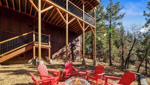 A wooden building with a fire pit and red chairs in the yard. - Shem Shack - Modern, Game Room, Wet Bar, Fire Pit (Big Bear City)