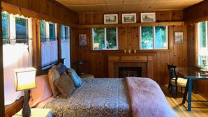 A cozy room with a bed, a fireplace, and a dining table. - Vintage home near Rose Bowl & JPL/NASA. So many trails great for active folks    (Altadena)