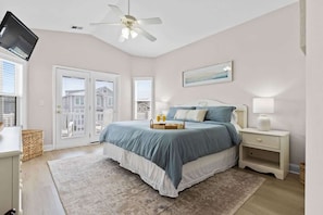 A bedroom with a bed, bedside table, lamp, and a ceiling fan. - Lost Shaker of Salt by Brunswick Vacation Rentals: OIB 2nd Row Home w/ Pool (Ocean Isle Beach)