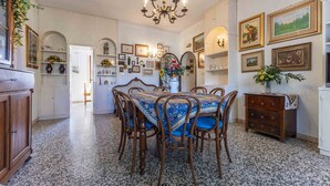 A dining room with a round table, chairs, and a chandelier. There are framed pictures on the walls and a cabinet with decorative items. - Wonderful private villa for 12 guests with WIFI, TV, balcony and pets allowed, close to Viareggio (Camaiore)