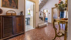 A hallway with a marble floor, a staircase, a wooden cabinet, and a vase with flowers. - Wonderful private villa for 12 guests with WIFI, TV, balcony and pets allowed, close to Viareggio (Camaiore)