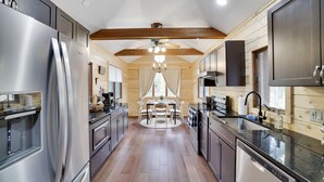 A modern kitchen with stainless steel appliances, wooden beams, and a central island. - Mins to Skiing! Hot Tub-Fire Pit-Hammock-BBQ-Games (Lake Harmony)