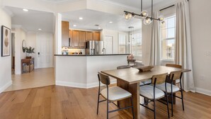 Una cocina amplia con armarios de madera, una isla central e iluminación colgante.