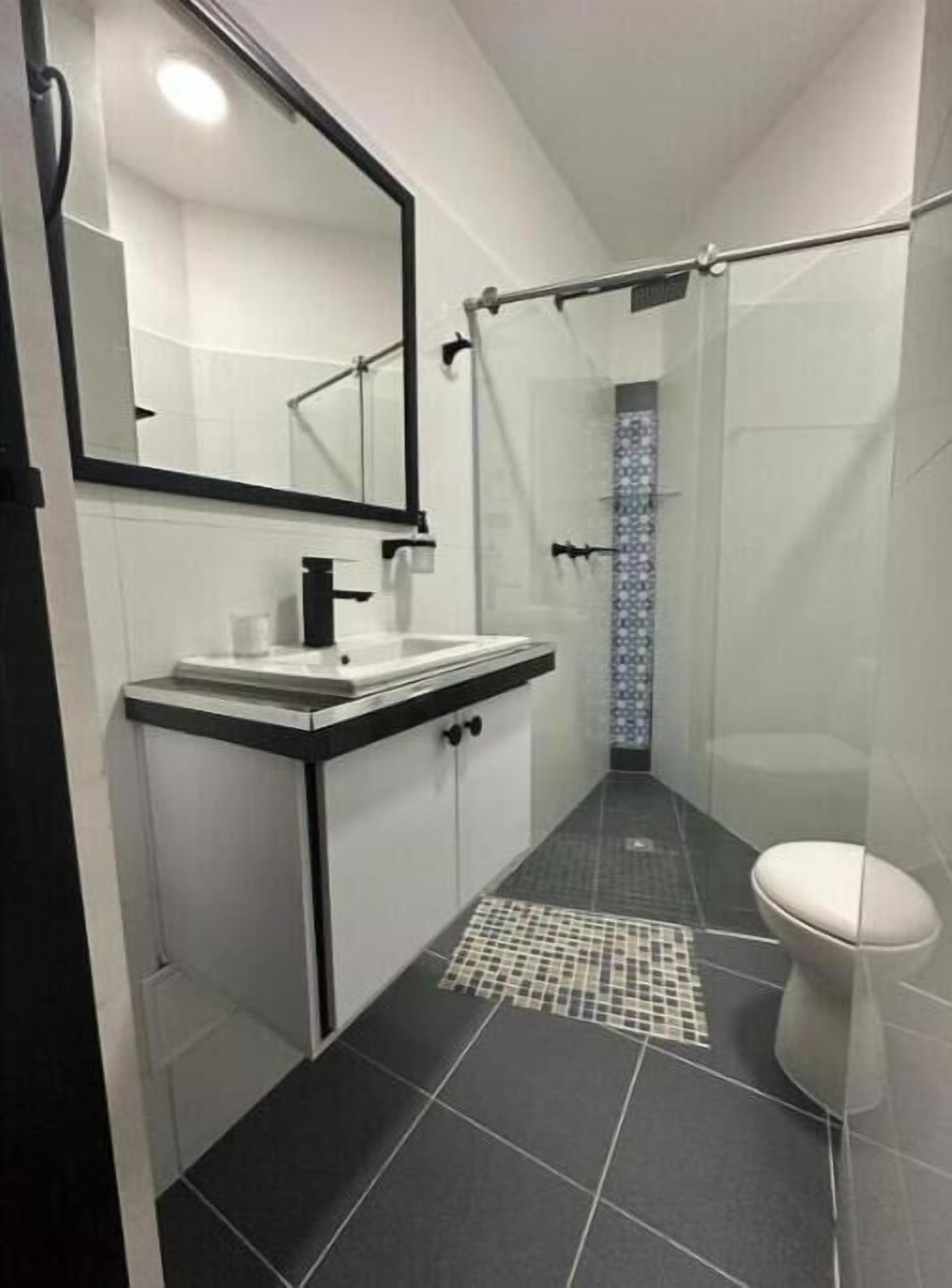 Een douche, handdoeken, zeep, toiletpapier