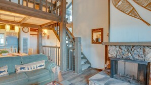 A cozy living room with a stone fireplace, a staircase, and a dining area with a kitchen in the background. - 1 Mi to Stagecoach Lift! Homey Tahoe Townhome (Stateline)