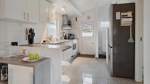 A modern kitchen with white cabinets, a central island, and a stainless steel refrigerator. - Nice home in Slagelse with WiFi (Slagelse)