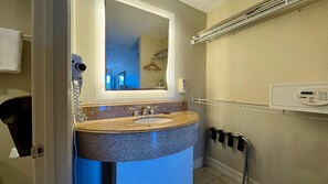 Une salle de bain avec un lavabo en granit, un miroir, un porte-serviettes et une serviette accrochée au mur.