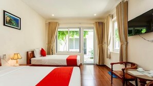 A hotel room with two beds, a TV, a desk, and a view of the outdoors. - Phú Long Bungalow (Phu Quoc)