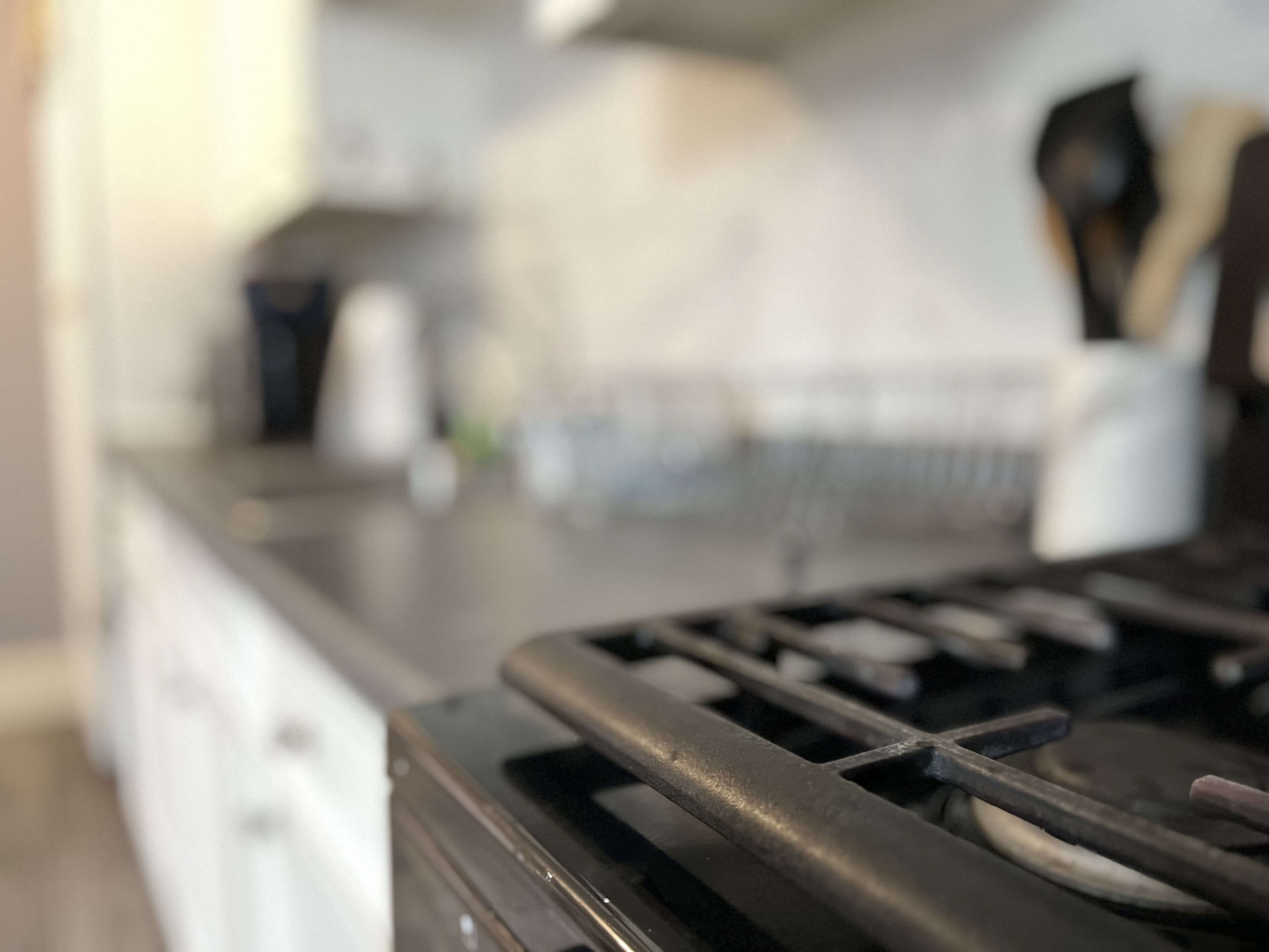 A kitchen with a stove, a sink, and a countertop.