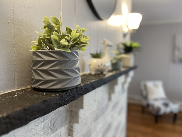 Ein modernes Interieur mit schwarzer Arbeitsplatte, einer strukturierten grauen Wand und einem Blumentopf.