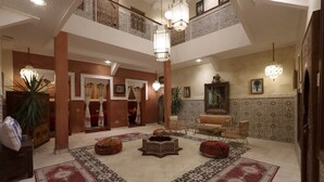 A spacious lobby with a high ceiling, ornate lighting fixtures, and a central seating area with a patterned rug. - Riad la fayette bed & breakfast  (Marrakech)