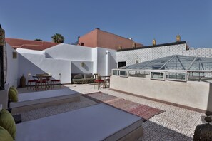 A rooftop terrace with a glass enclosure, outdoor seating, and a patterned floor. - Riad la fayette bed & breakfast  (Marrakech)