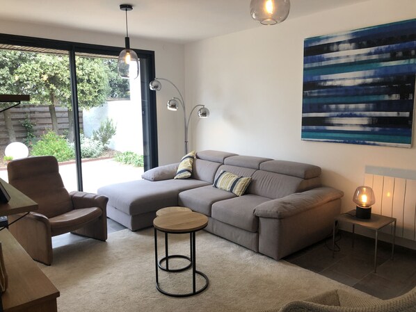 A modern living room with a sectional sofa, a round coffee table, and a floor lamp.