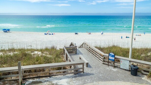 A wooden boardwalk leading to a beach with clear blue water, beach chairs, and umbrellas. - Cassine- 3 Min to Beach, 2 BR, Pool, Bikes, Tennis & Beach (Santa Rosa Beach)