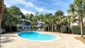 A rectangular swimming pool with a tiled deck, surrounded by palm trees and a fence. - Cassine- 3 Min to Beach, 2 BR, Pool, Bikes, Tennis & Beach (Santa Rosa Beach)