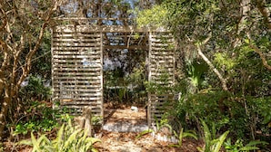 A wooden pergola structure surrounded by dense foliage and ferns. - Cassine- 3 Min to Beach, 2 BR, Pool, Bikes, Tennis & Beach (Santa Rosa Beach)