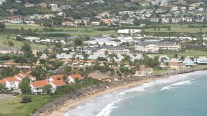 Un quartier résidentiel situé sur la côte, avec des maisons, une plage et une vue sur l’océan.