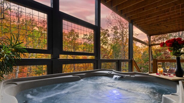 Un bain à remous avec vue sur les arbres aux couleurs automnales, grâce à de grandes fenêtres.