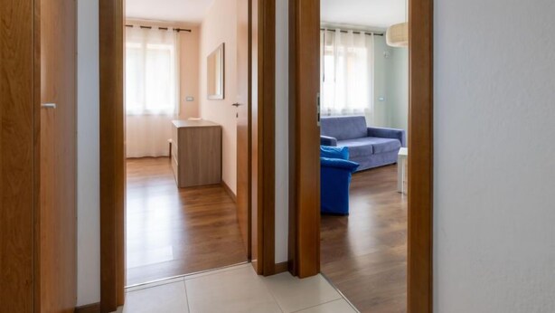Un couloir mène à un espace de vie comprenant un canapé et une petite table.