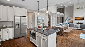A spacious kitchen with a central island, stainless steel appliances, and pendant lighting. - Ruby Arrival by SoCharm | Luxury on Lake Norman (Mooresville)