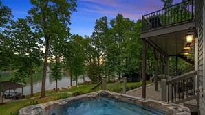 A hot tub with a wooden deck and a view of a lake. - Ruby Arrival by SoCharm | Luxury on Lake Norman (Mooresville)