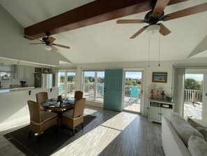 Una cocina amplia con comedor, ventilador de techo y vistas al exterior.