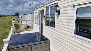A row of mobile homes with a covered patio area and a fenced deck. - Driftwood Cabin Dog Friendly - Anderby Creek (Anderby creek)