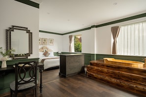 A room with a bed, a desk, a mirror, and a wooden bathtub. - The Gate Boutique Hotel Sapa (Sa Pa)