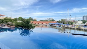 A swimming pool with a view of a marina and buildings in the background. - Casa Del Rio Residence (Malacca City)