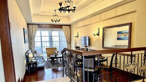 A spacious living area with a high ceiling, a chandelier, a large mirror, and a comfortable seating arrangement. - Casa Del Rio Residence (Malacca City)